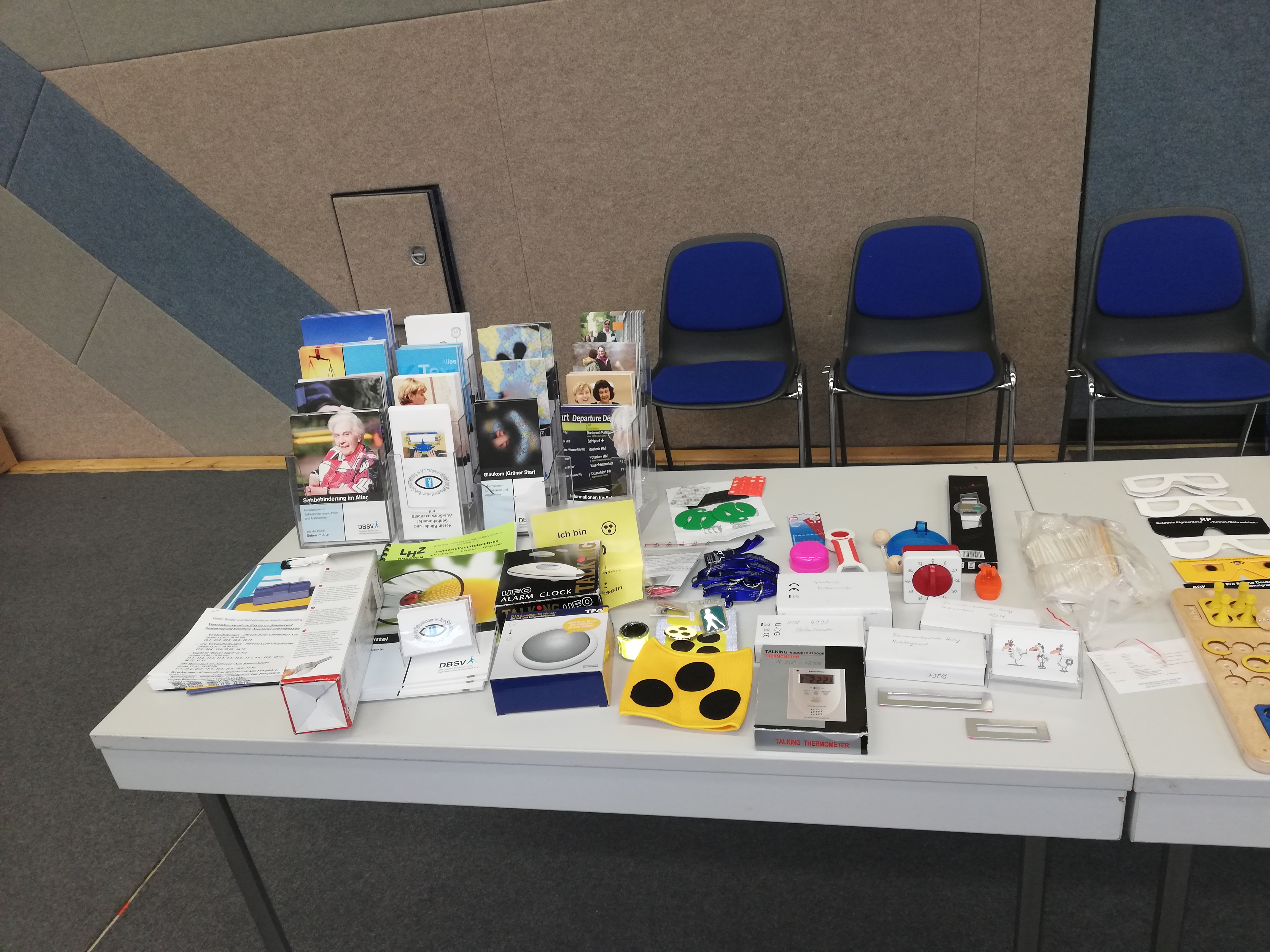 Auf einem großen Tisch haben wir Hilfsmittel und Spiele für Menschen mit Seheinschränkungen vorgestellt.